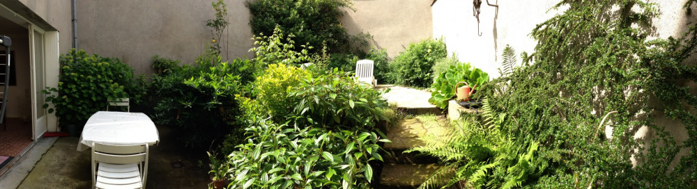 jardin clos et sécurisé avec table, chaises et chaises longues